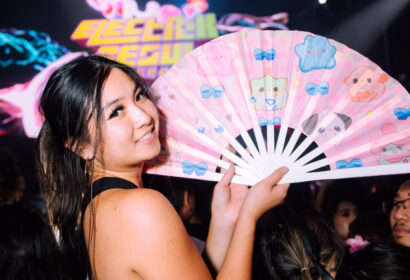 Guest holding up fan smiling at Time Nightclub